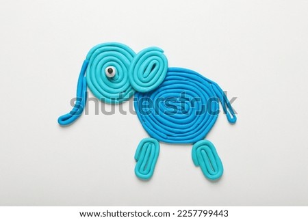 Light blue plasticine elephant isolated on white, top view
