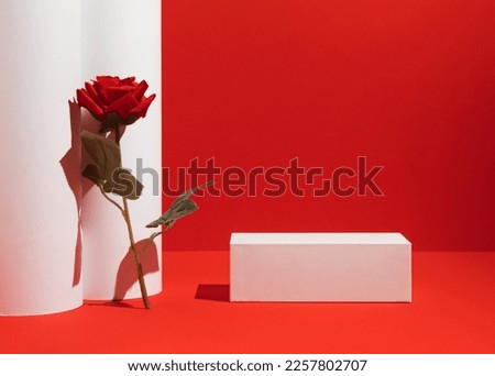 Suitable for Product Display and Business Concept. Modern aesthetic. Product podium and red rose flower on red  background. Elegant beauty concept.