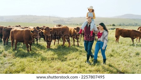 Family, farm and agriculture with a girl, mother and father walking on grass in a meadow with cows. Farmer, sustainability and field with a man, woman and daughter working together in cattle farming Royalty-Free Stock Photo #2257807495