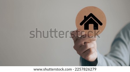 Real estate concept, investment, person holding circle sign and house icon.
