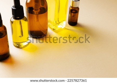 Image of glass bottles with pumps and copy space on yellow background. Plastic free beauty, health and beauty, sustainability concept.