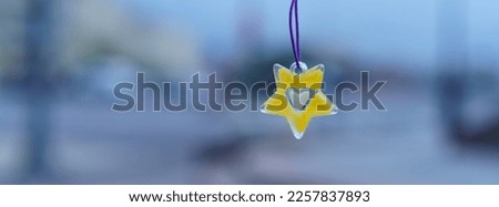Children's decoration. Heart inside of the yellow star. Blurred  Moscow cityscape as background. Close up image