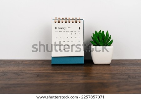 February 2023 desk calendar with potted plant