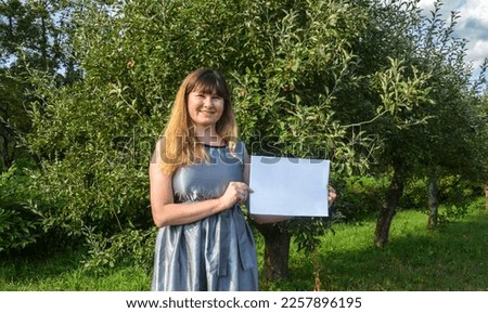 Woman holding blank of a white sheet of paper. Placard board for your text 