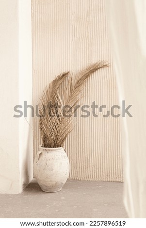 light still life with dry palm leaves in a beige vase. Topics of relaxation and recuperation