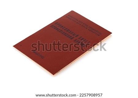 Trade union card of the USSR, a ticket on a white background. Retro case made of red leatherette. Russian and Ukrainian text - "trade union card, workers of all countries unite" and "trade union card"