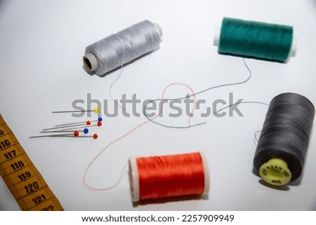 sewing thread forming a shape of heart with some other sewing equipment on the picture.