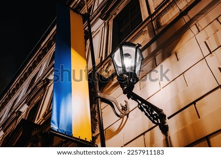 Ukrainian flag on european building near night lantern. High quality photo