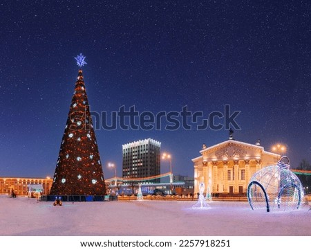 Gomel, Belarus. Amazing Bright Starry Sky Above Xmas Christmas Tree In Lenin Square And Drama Theatre With Christmas New Year Decorations In Evening Night Illumination. Evening Night Scenic View Of