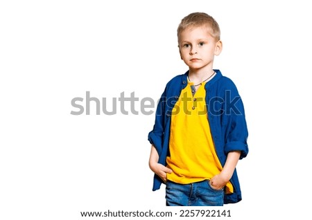 Portrait of a beautiful kid boy in yellow T-shirt and denim jacket, shirt. Boy standing on a white background.