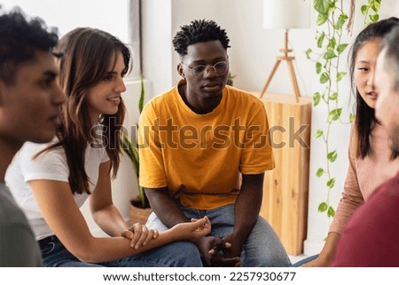 Multiracial people sitting in circle during group therapy supporting each other. Diversity, mental health and support concept. People communicating while sitting in circle and gesturing. Royalty-Free Stock Photo #2257930677