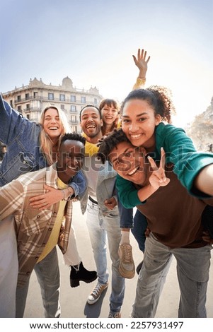 Vertical photo of a group of cheerful students college friends having fun together as they travel European city Happy community of diverse people. Selective focus on the smily couple taking the selfie Royalty-Free Stock Photo #2257931497