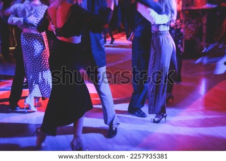 Couples dancing traditional latin argentinian dance milonga in the ballroom, tango salsa bachata kizomba lesson in the red and purple lights, dance festival
 Royalty-Free Stock Photo #2257935381
