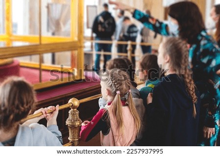 Group of kids children on excursion visit gallery museum with tour guide, a docent with a young teen school visitors on an art exhibition Royalty-Free Stock Photo #2257937995