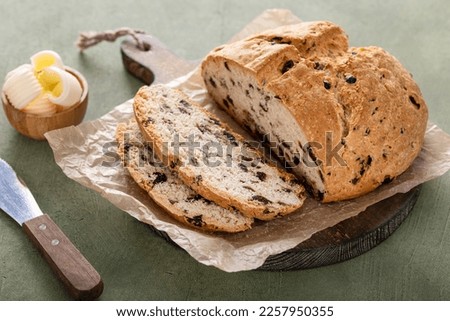 Soda bread in a cast iron pan with cranberries and pecans sliced and served with irish butter, irish recipe idea with St Patricks day Royalty-Free Stock Photo #2257950355
