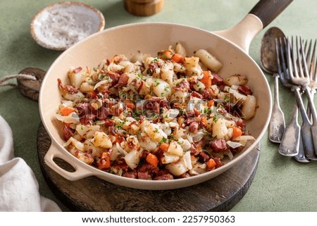 Corned beef hash with potatoes, cabbage and carrot in a cast iron pan Royalty-Free Stock Photo #2257950363