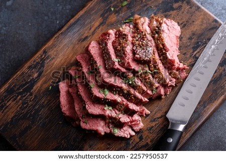 Corned beef cooked and sliced on a cutting board, irish recipe idea for St Patricks day Royalty-Free Stock Photo #2257950537