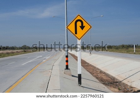 Yellow square sign to u-turn ahead on new concrete road