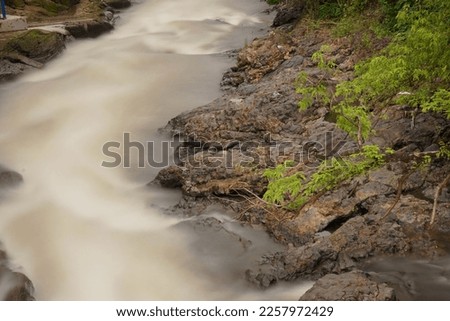 picture of a river with swift water flow and pillow lava  rocks in Yogyakarta, Indonesia, long exposure shot.