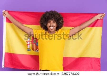 Happy african man raising a spanish flag