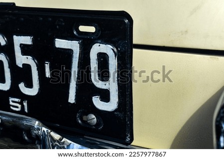 Black and white vintage car metal license plate close up partial view