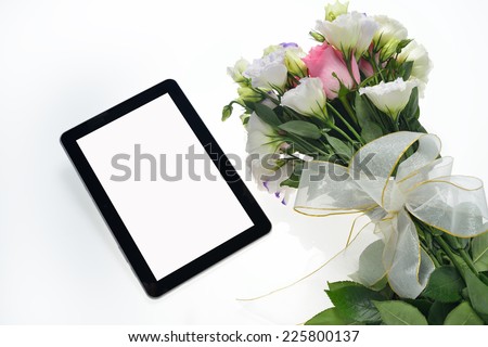 Tablet computer and beautiful bouquet of flowers isolated on white