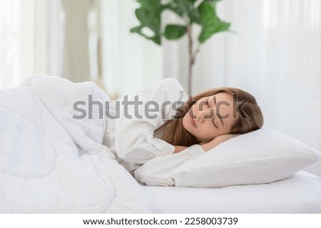 Beautiful Attractive Asian woman sleep and sweet dream lying on bed in cozy bedroom in the morning feeling so relax and comfortable.Healthy Young female sleep with bedtime at home.Healthcare Concept Royalty-Free Stock Photo #2258003739