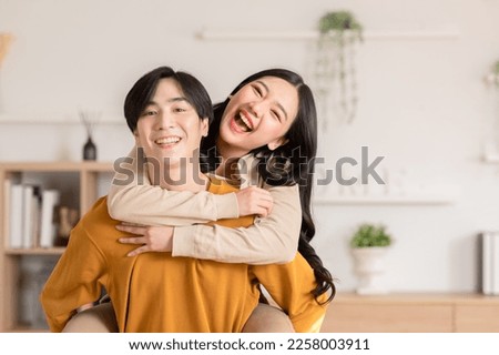 Asian young couple hugging with positive emotion and loving together at warmth place. Attractive man and woman embracing spending time together at home. Couple love and Valentine's Day concept