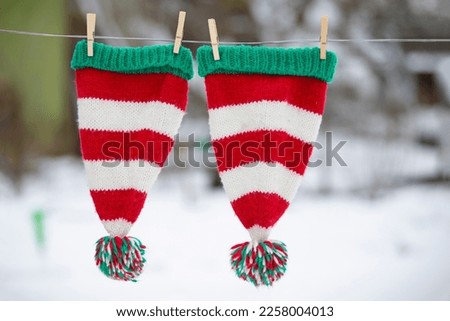 Christmas striped hats are dried on a rope. Preparing to celebrate Christmas.