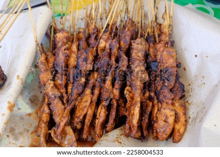 chiken satay (sate ayam) with peanut sauce. One of the popular street food in Indonesia. oil paper mat