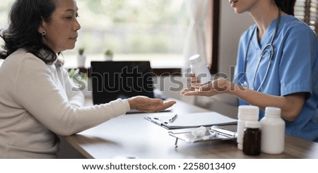 Asian Female Doctor examining and taking note on checklist paper with female patients in medical room.
