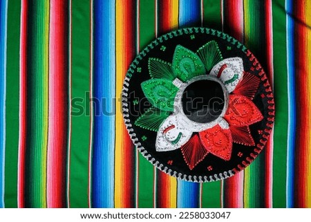 Mariachi hat with the colors of the Mexican flag on a colorful serape. Mexican sombrero. Royalty-Free Stock Photo #2258033047