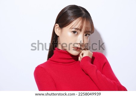 Beauty portrait of young Asian woman in red knit Royalty-Free Stock Photo #2258049939