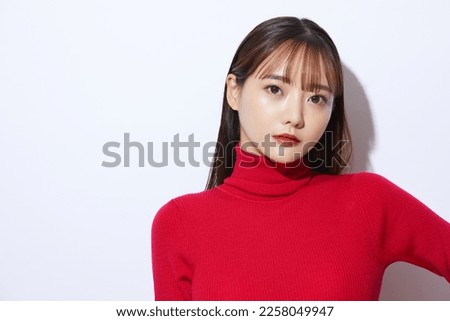 Beauty portrait of young Asian woman in red knit Royalty-Free Stock Photo #2258049947