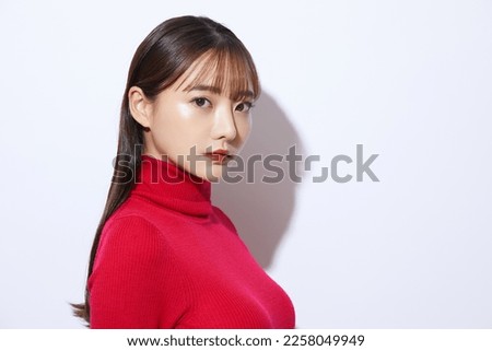 Beauty portrait of young Asian woman in red knit Royalty-Free Stock Photo #2258049949