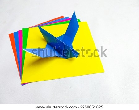 Blue bird origami and colorful papers, isolated on white background
