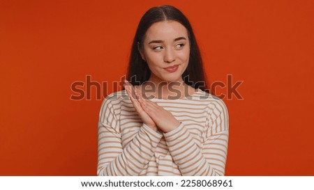 Sneaky cunning pretty woman with tricky face gesticulating and scheming evil plan, thinking over devious villain idea, cheats, revenge, jokes, pranks. Young girl isolated on red studio background Royalty-Free Stock Photo #2258068961