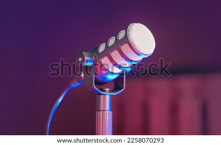 Podcast Microphone on Table with RGB Red and Blue Highlight Colors on dark background