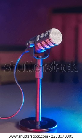 Podcast Microphone on Table with RGB Red and Blue Highlight Colors on dark background