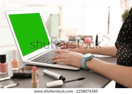 Young woman using laptop at desk, closeup. Device display with chroma key