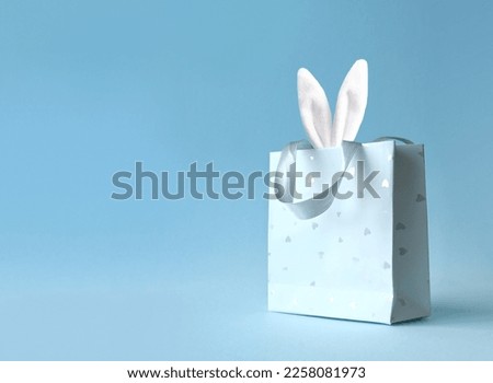Easter bunny ears in a paper bag. Blue background. Space for text. Happy easter