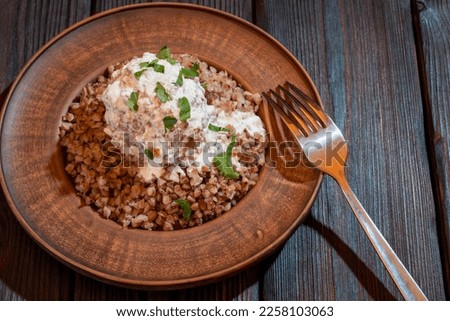 Buckwheat porridge with meatballs with cream sauce on a plate top view. Background picture.