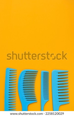 Blue combs on a yellow background. Copy space. View from above.