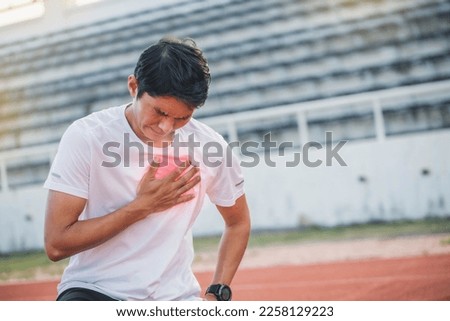 Man runner athlete chest injury and pain. sport man having chest pain after running in the park , heart attack. Asian cardiac arrest running young man heart attack in park. Royalty-Free Stock Photo #2258129223