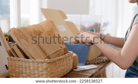 Eco vendor go green packaging parcel carton box in net zero waste store asian seller retail shop. Earth care day small SME owner asia people wrap reuse brown paper pack gift reduce plastic free order. Royalty-Free Stock Photo #2258138527