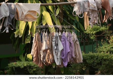 a stainless underwear hanger full of colorful clothes to dry in the sun 