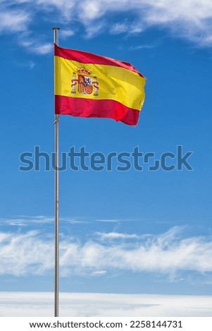 Spanish flag hoisted on the mast in the wind with blue sky Royalty-Free Stock Photo #2258144731