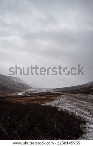 Icelandic landscape half snowy on a day with fog and clouds