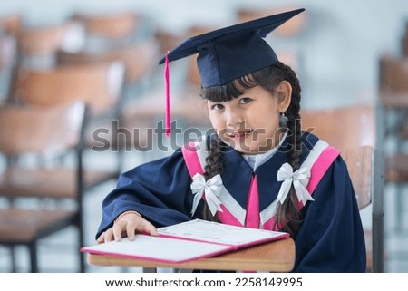 A proud child graduate dressed in gown and cap symbolizing educational success and achievement