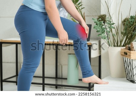 Knee pain, woman suffering from ache and doing self-massage at home, self-soothing massaging, BeH3althy concept photo